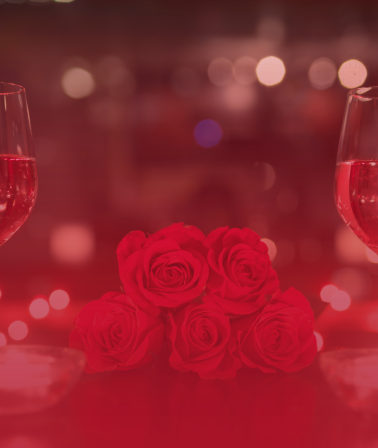 Valentine's Day: 2 wine glasses on a dinner table and red roses
